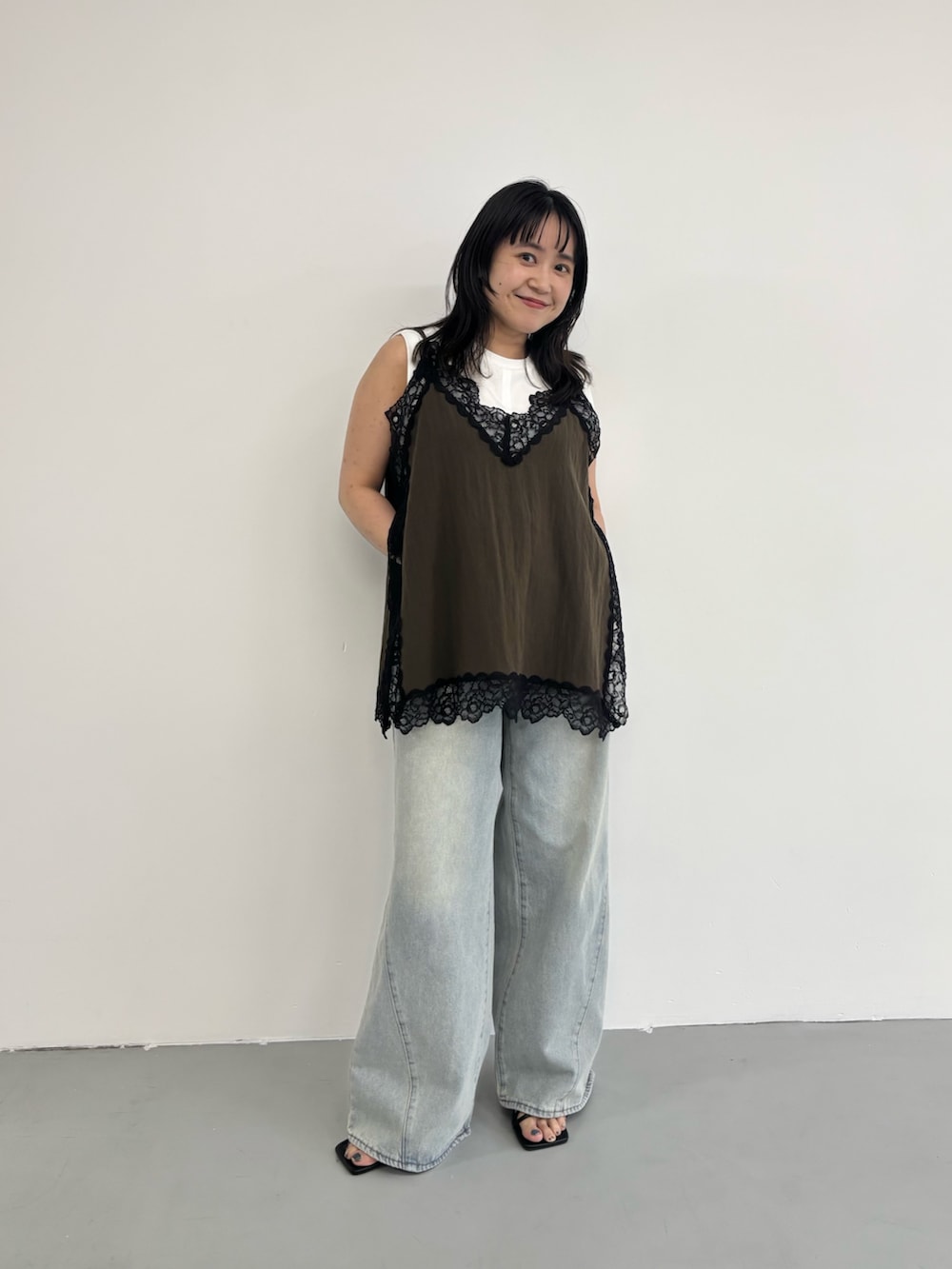 ブルー系のデニムパンツ、ブラウン系のキャミソールを着用したレディースの春コーディネートの2枚目の写真