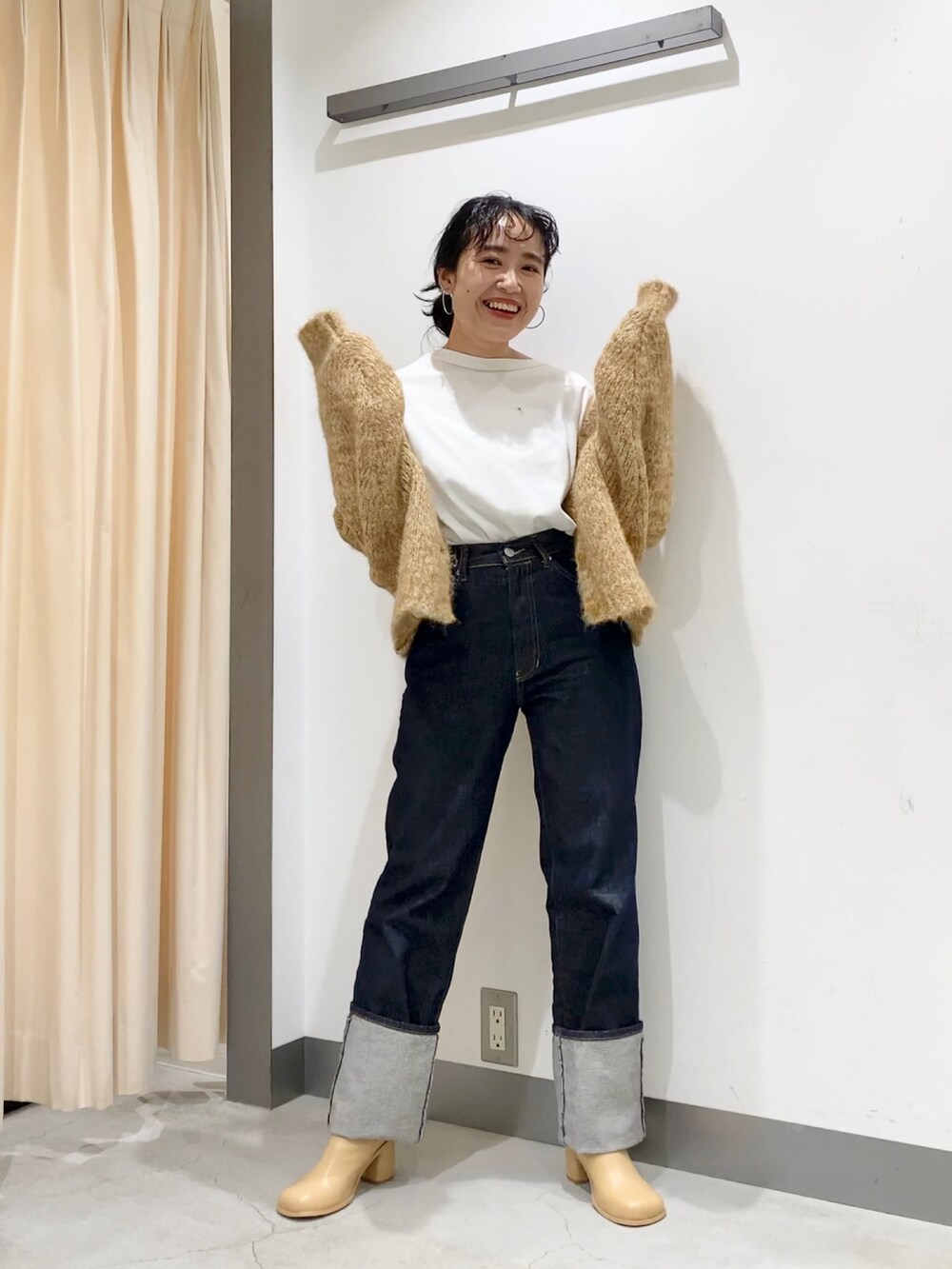 ベージュ系のカーディガン/ボレロ、ブルー系のデニムパンツ、ベージュ系のブーツを着用したレディースの秋コーディネートの2枚目の写真