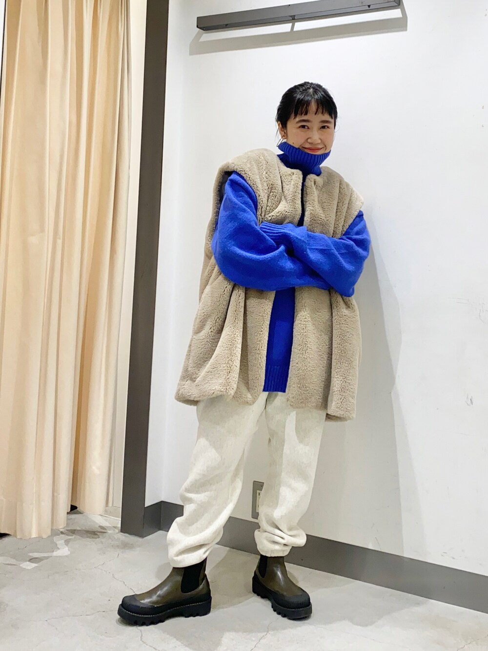 ブルー系のニット/セーター、ベージュ系のジャケット/アウター、ホワイト系のパンツを着用したレディースの冬コーディネートの2枚目の写真