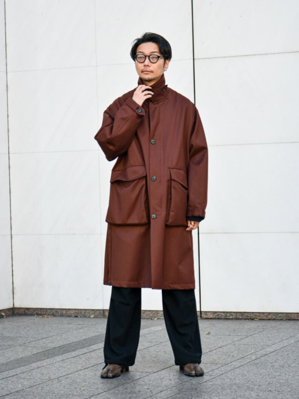 ブラウン系のその他アウター、ブラック系のスラックスを着用したメンズの冬コーディネートの2枚目の写真