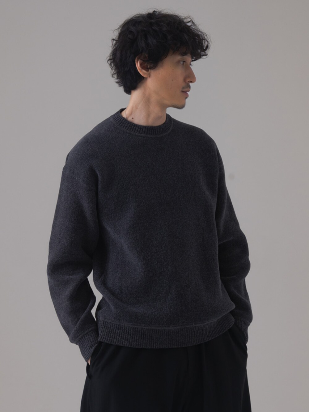 グレー系のスニーカー、ブラック系のスラックス、グレー系のニット/セーターを着用したメンズの秋コーディネートの2枚目の写真