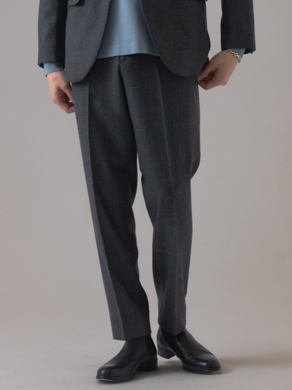 ブラック系のブーツ、グレー系のテーラードジャケット、グレー系のスラックスを着用したメンズの秋コーディネートの3枚目の写真