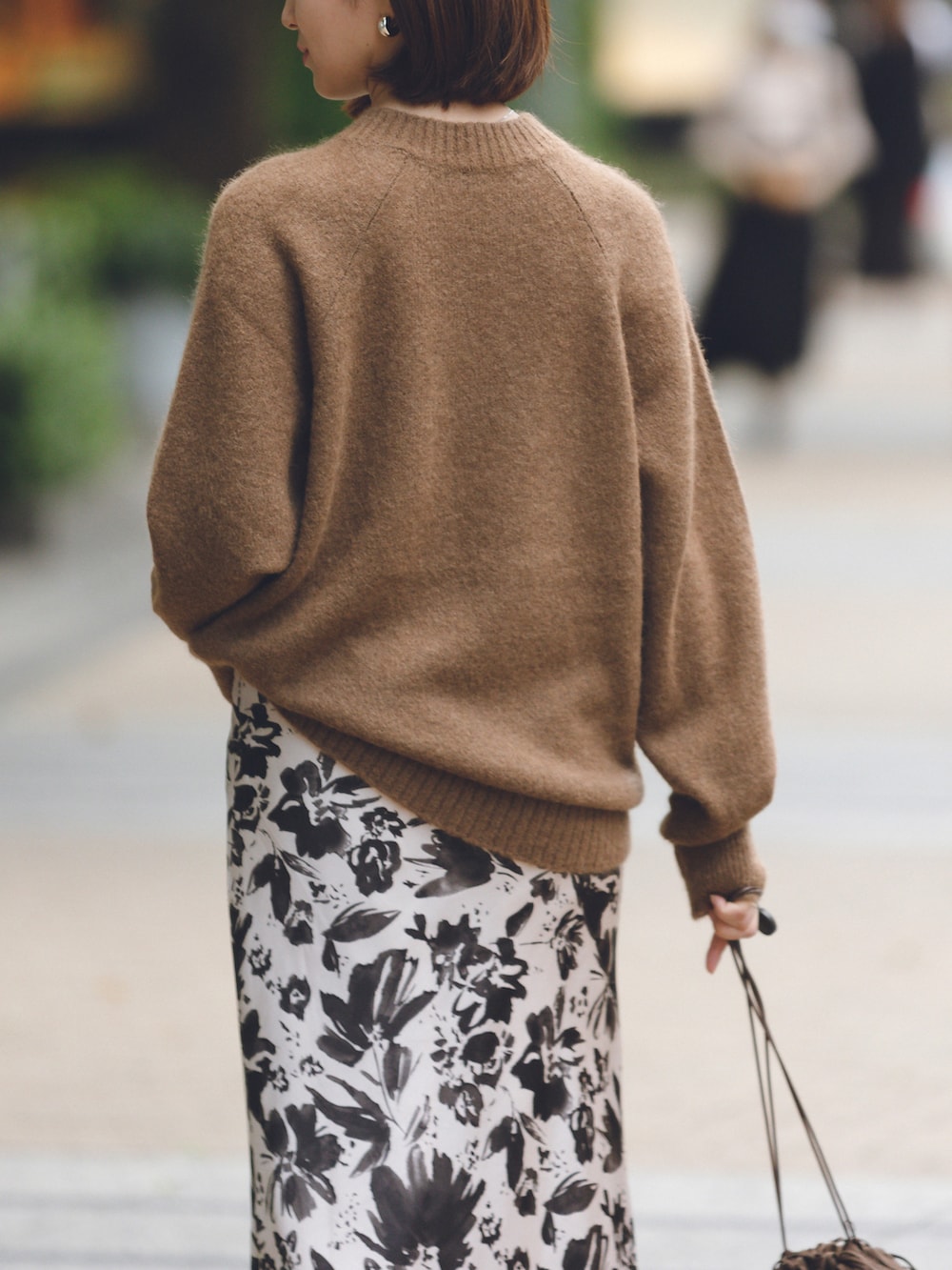 ベージュ系のスカート、ブラウン系のニット/セーター、ブラウン系のバッグを着用したレディースの秋コーディネートの3枚目の写真