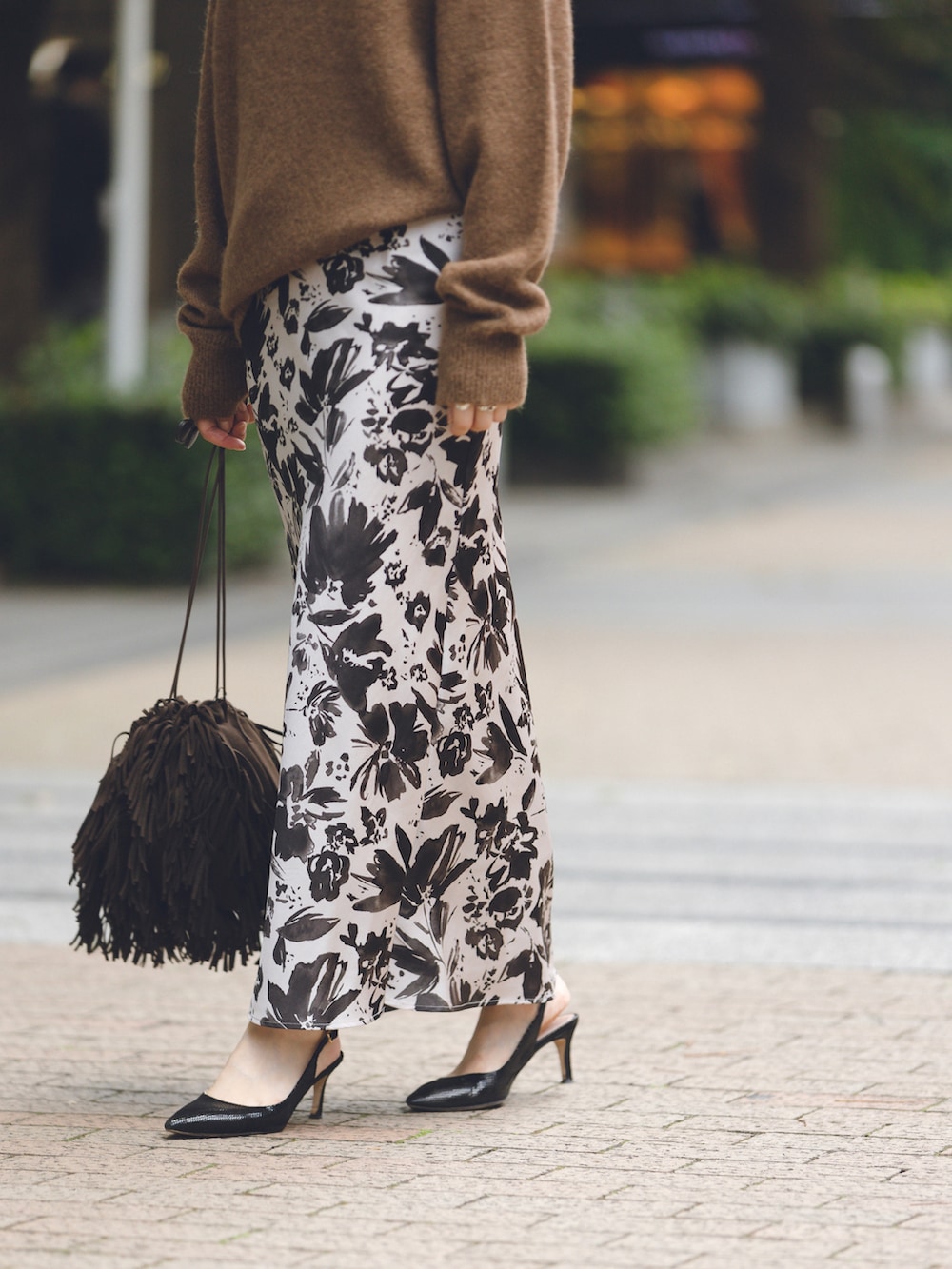 ベージュ系のスカート、ブラウン系のニット/セーター、ブラウン系のバッグを着用したレディースの秋コーディネートの4枚目の写真