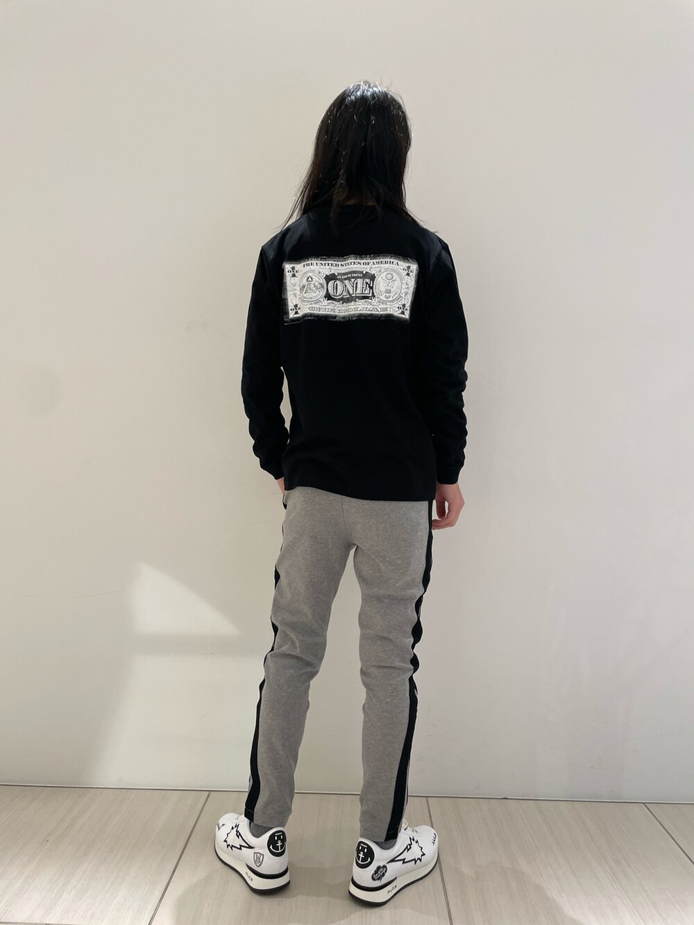 グリーン系のスウェットパンツ、ブラック系のTシャツ/カットソー、ホワイト系のスニーカーを着用したメンズの冬コーディネートの2枚目の写真