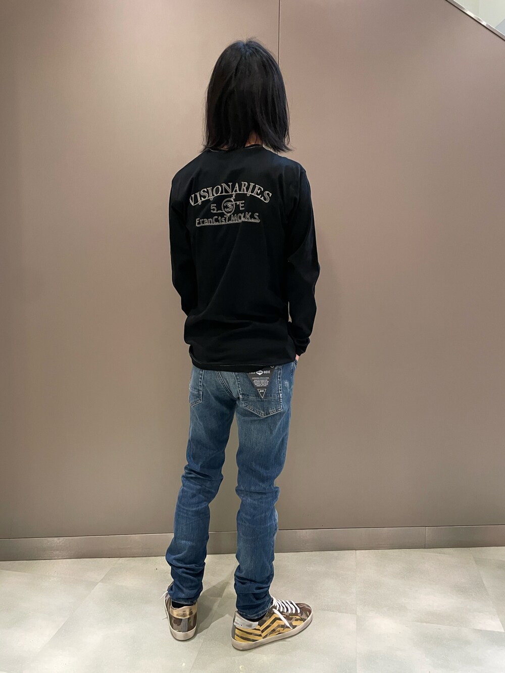 ブラック系のTシャツ/カットソー、ブルー系のデニムパンツ、その他のスニーカーを着用したメンズの冬コーディネートの2枚目の写真