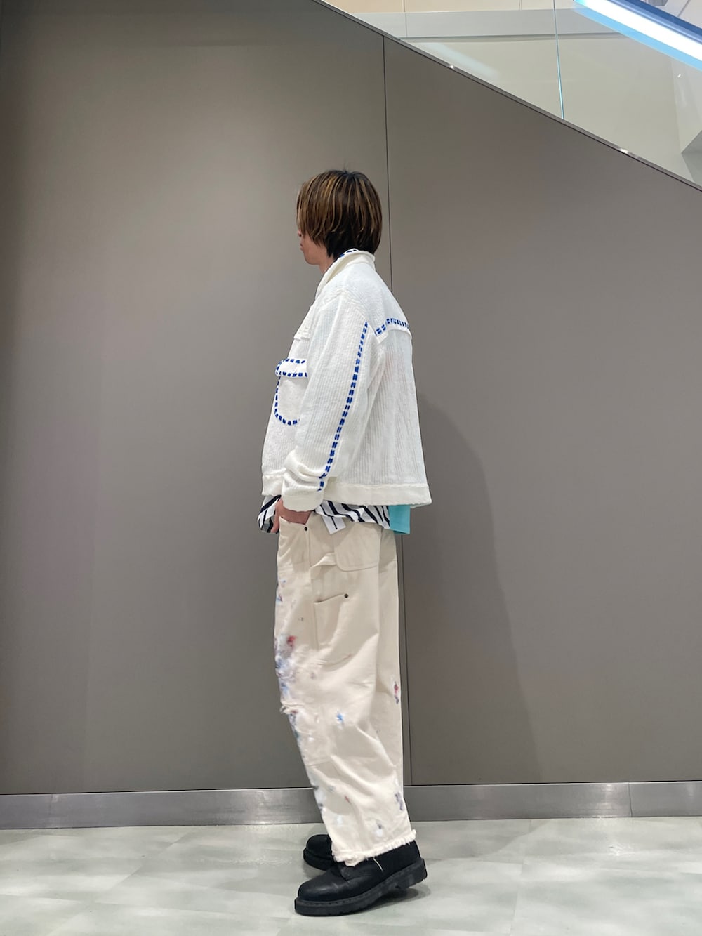 ブルー系のポロシャツ、ホワイト系のカーディガン/ボレロ、ホワイト系のパンツを着用したメンズの春コーディネートの2枚目の写真