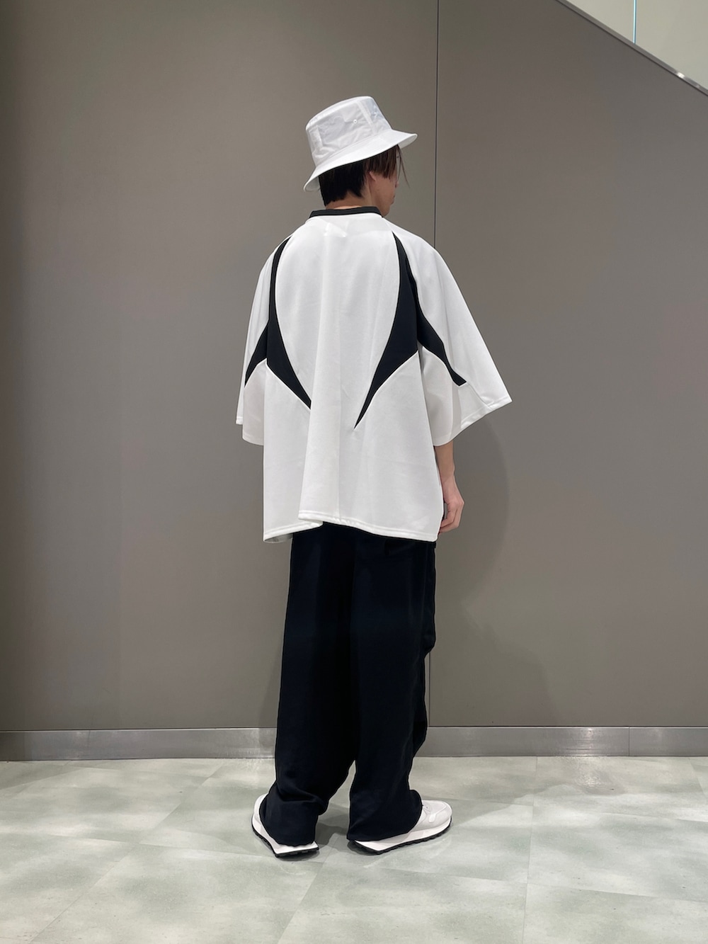 ホワイト系のTシャツ/カットソー、ブラック系のパンツ、ホワイト系のスニーカーを着用したメンズの春コーディネートの2枚目の写真