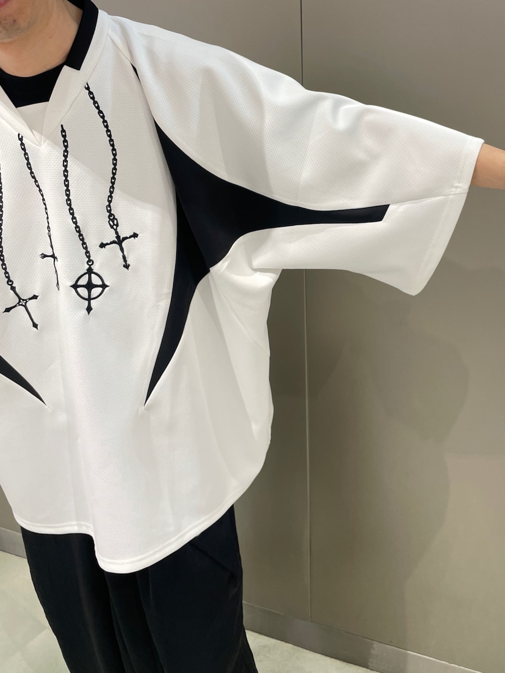 ホワイト系のTシャツ/カットソー、ブラック系のパンツ、ホワイト系のスニーカーを着用したメンズの春コーディネートの5枚目の写真