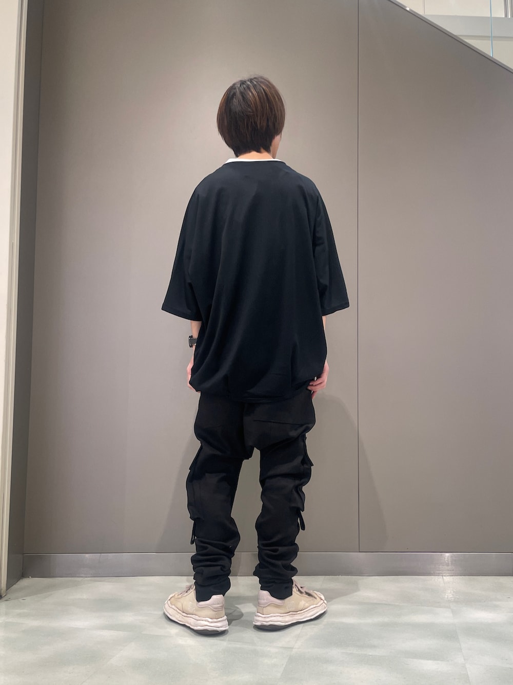 ブラック系のデニムパンツ、ブラック系のTシャツ/カットソー、ホワイト系のスニーカーを着用したメンズの春コーディネートの3枚目の写真