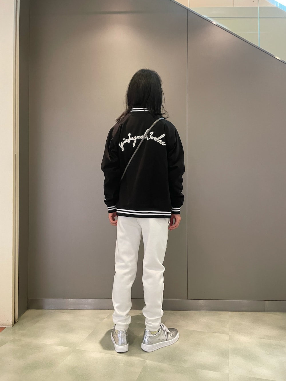 ホワイト系のTシャツ/カットソー、ブラック系のスタジャン、ブラック系のバッグを着用したメンズの秋コーディネートの2枚目の写真