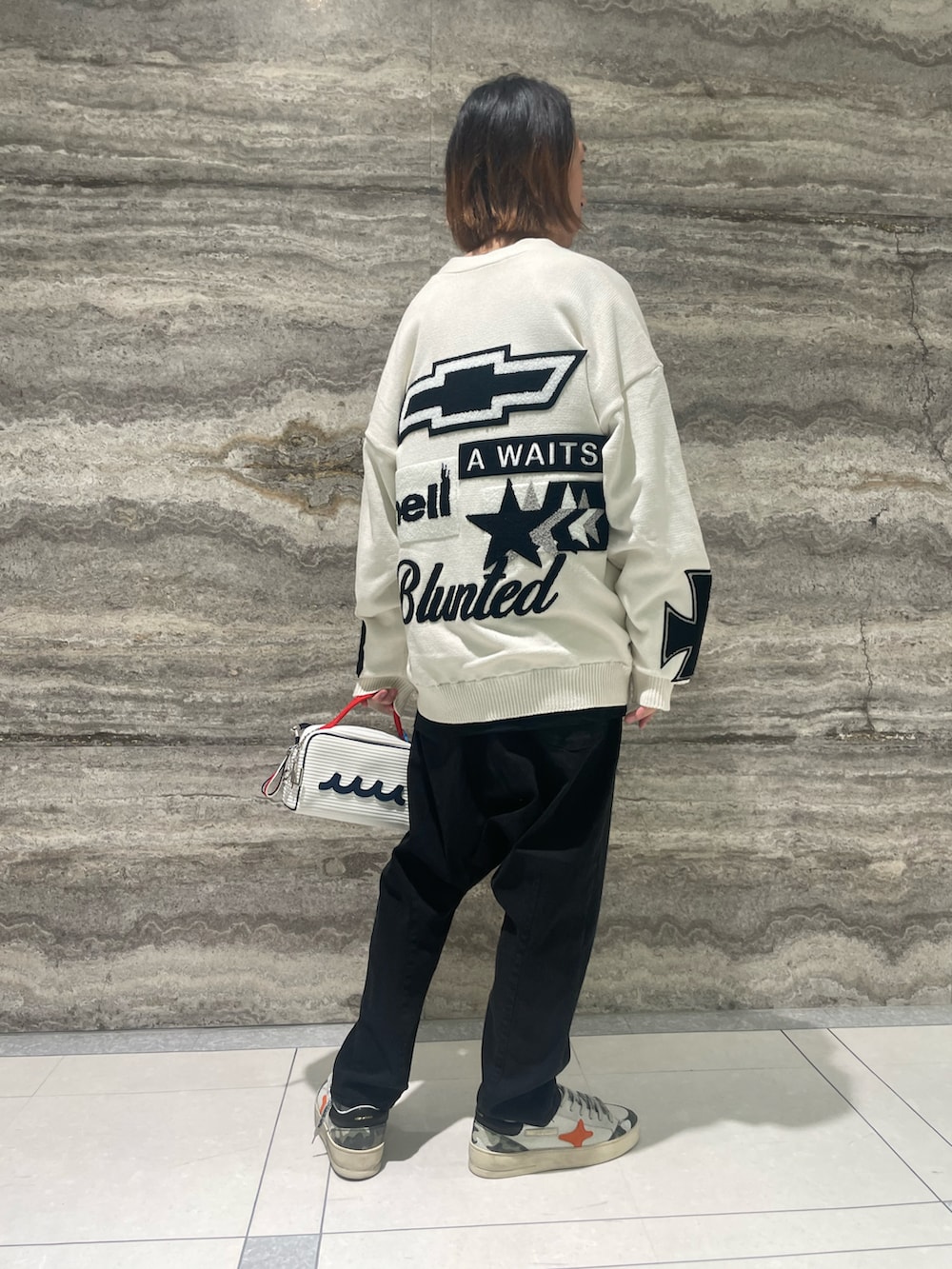 ホワイト系のカーディガン/ボレロ、ブラック系のスラックス、ホワイト系のスニーカーを着用したメンズの秋コーディネートの2枚目の写真