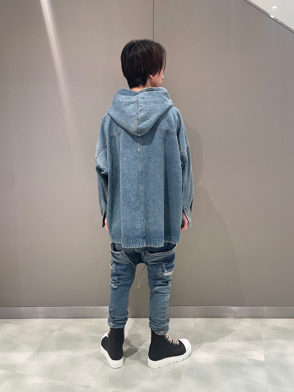 ブルー系のブルゾン、ブルー系のデニムパンツ、ブラック系のブーツを着用したメンズの夏コーディネートの3枚目の写真