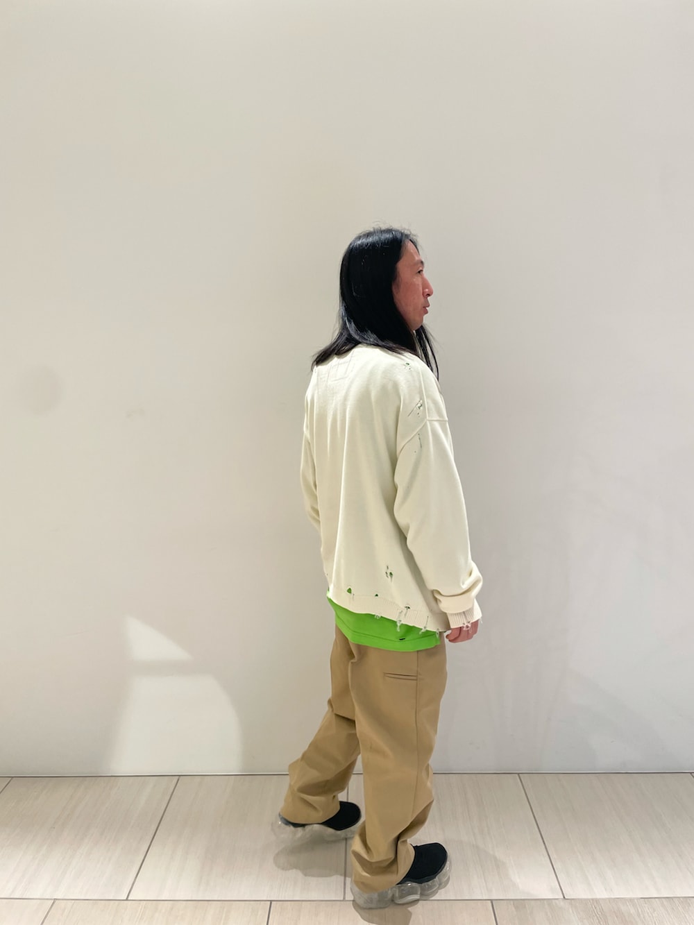ベージュ系のパンツ、グリーン系のTシャツ/カットソー、ホワイト系のカーディガン/ボレロを着用したメンズの冬コーディネートの2枚目の写真