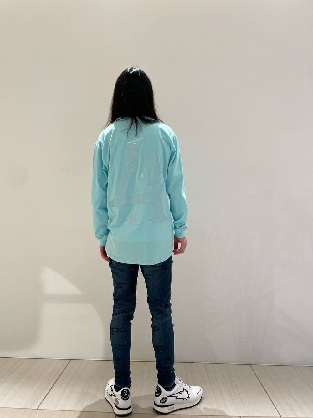 ブルー系のTシャツ/カットソー、ブルー系のデニムパンツ、ホワイト系のスニーカーを着用したメンズの冬コーディネートの2枚目の写真