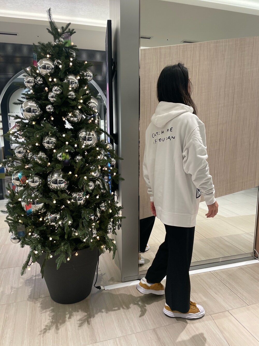 ホワイト系のパーカー、ブラック系のその他パンツ、ベージュ系のスニーカーを着用したメンズの秋コーディネートの2枚目の写真