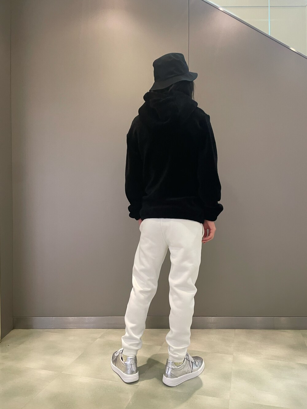 ブラック系のブルゾン、ホワイト系のパンツ、シルバー系のスニーカーを着用したメンズの秋コーディネートの2枚目の写真