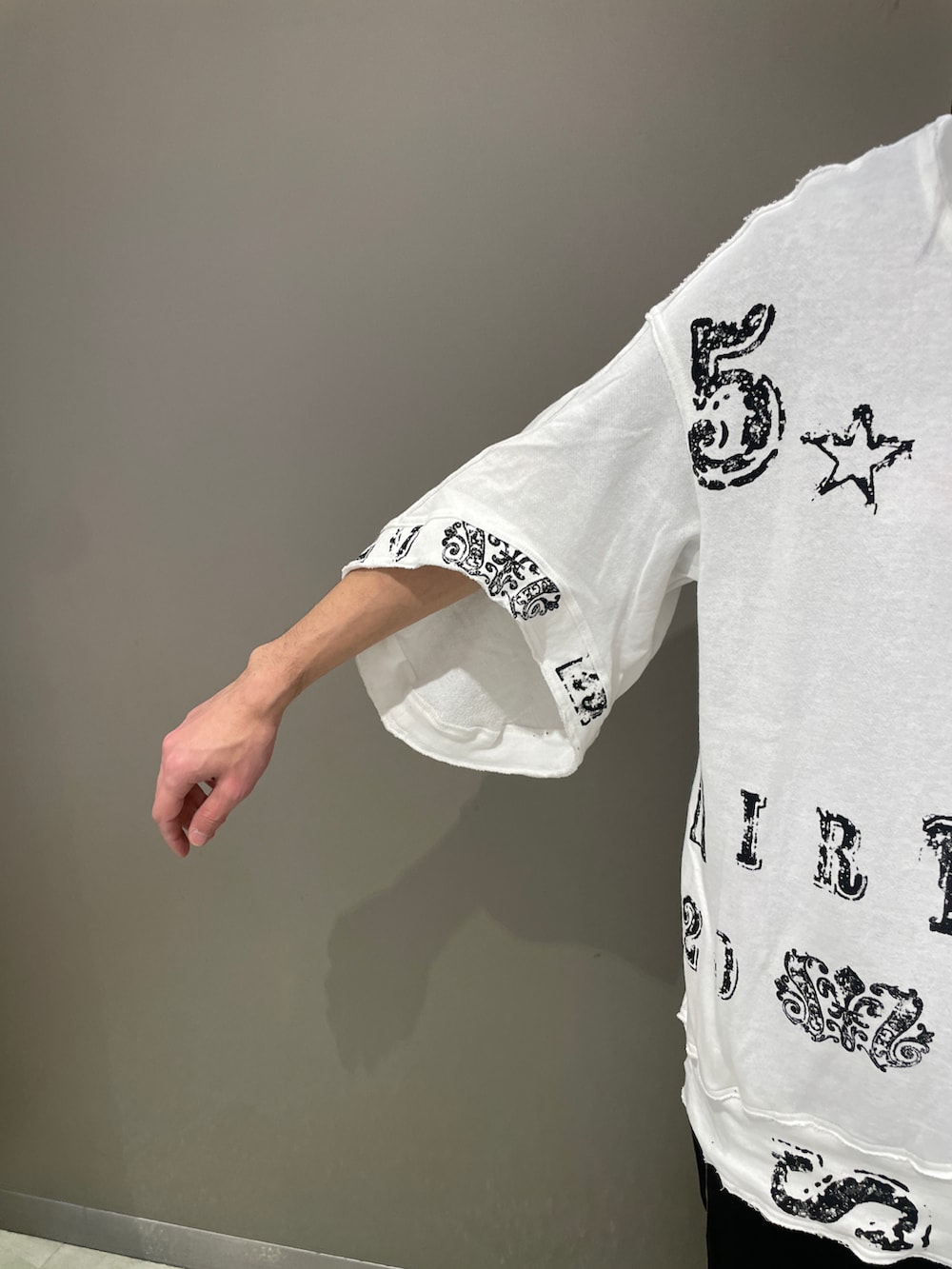 ホワイト系のTシャツ/カットソー、ブラック系のパンツ、ブラック系のスニーカーを着用したメンズの春コーディネートの3枚目の写真