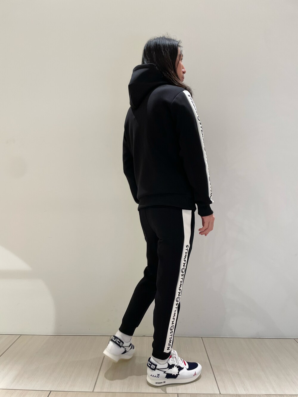 ブラック系のパーカー、ブラック系のその他パンツ、ホワイト系のスニーカーを着用したメンズの冬コーディネートの2枚目の写真