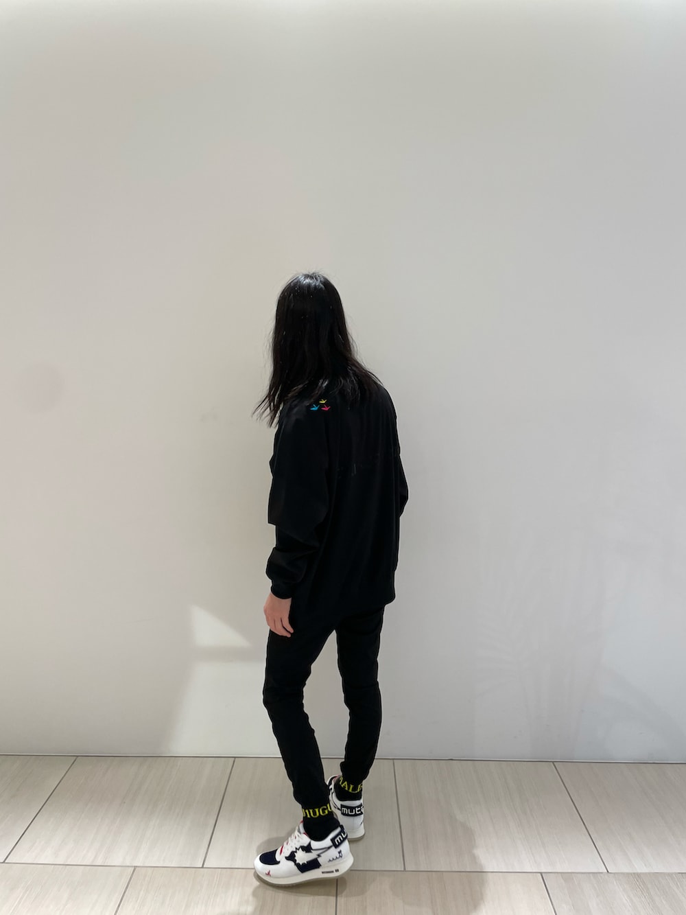 ブラック系のスウェット、イエロー系のパンツ、ホワイト系のスニーカーを着用したメンズの冬コーディネートの2枚目の写真