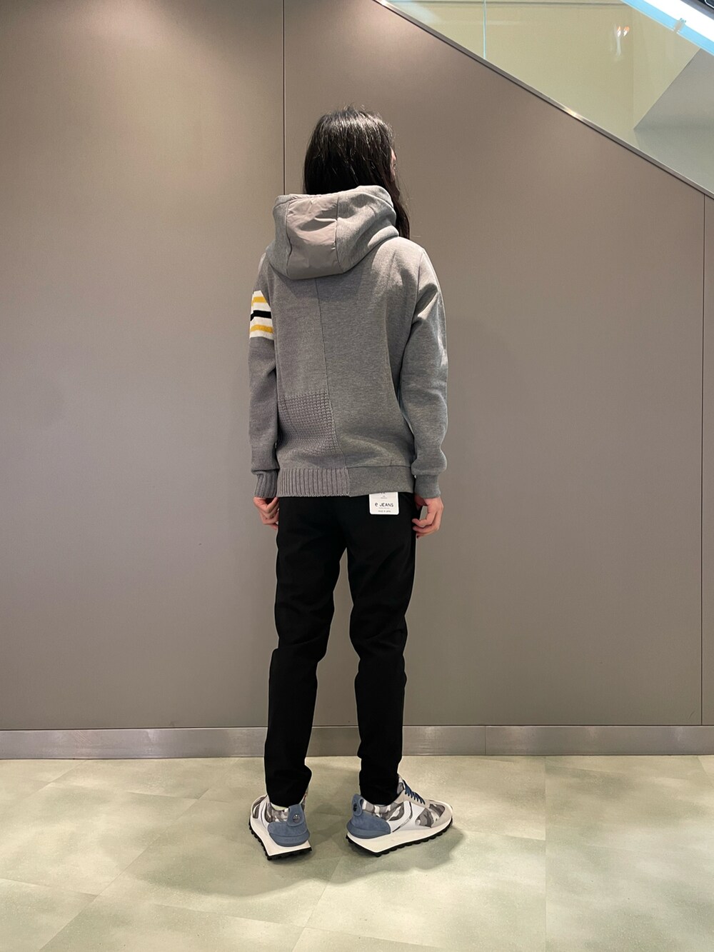 グレー系のパーカー、ブラック系のスラックス、グレー系のスニーカーを着用したメンズの夏コーディネートの2枚目の写真