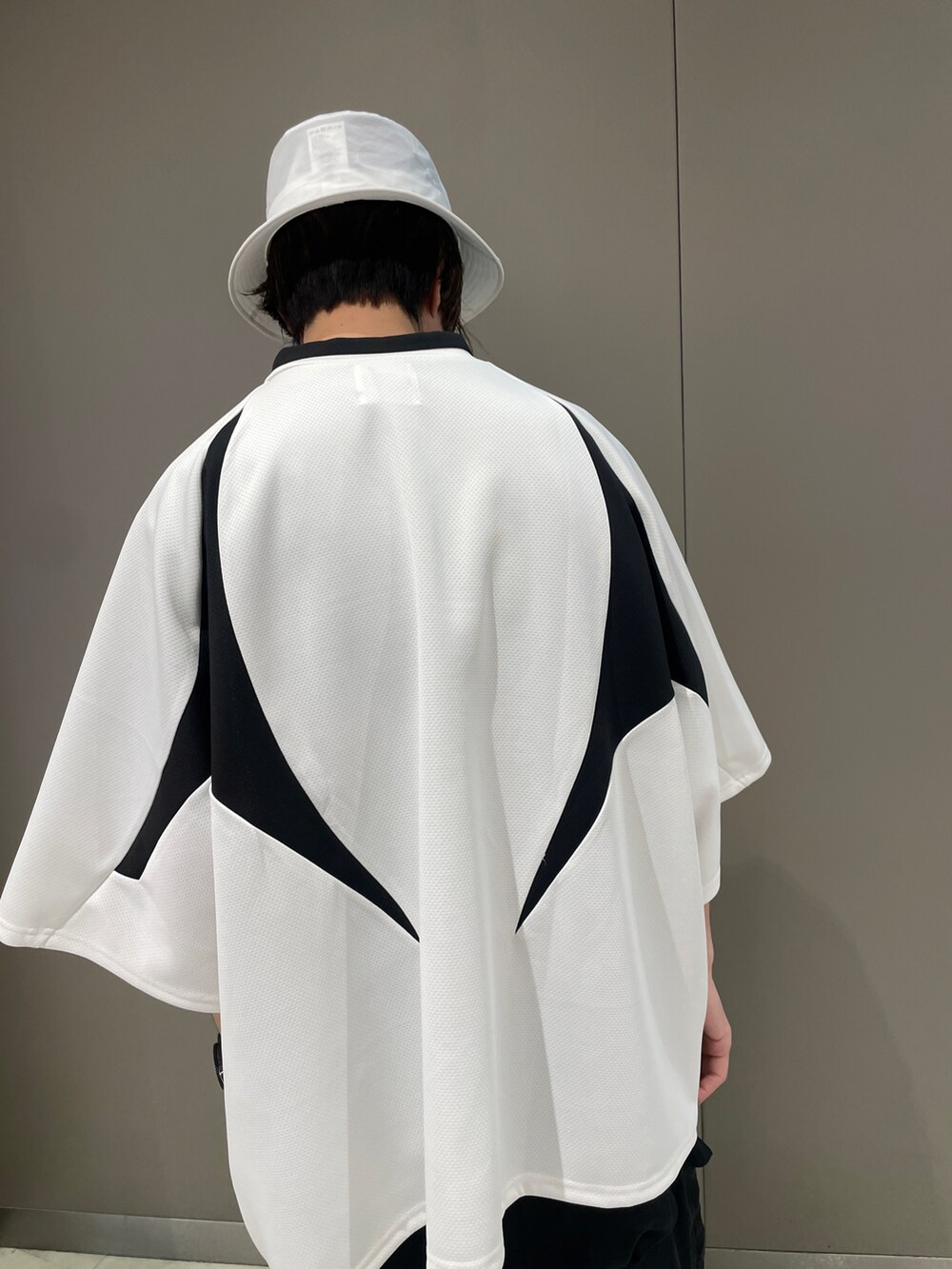 ホワイト系のTシャツ/カットソー、ブラック系のパンツ、ホワイト系のスニーカーを着用したメンズの春コーディネートの4枚目の写真