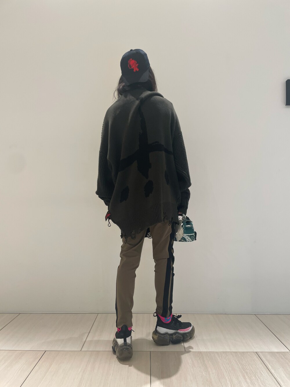 グリーン系のニット/セーター、グリーン系のスウェットパンツ、ブラック系のスニーカーを着用したメンズの秋コーディネートの2枚目の写真