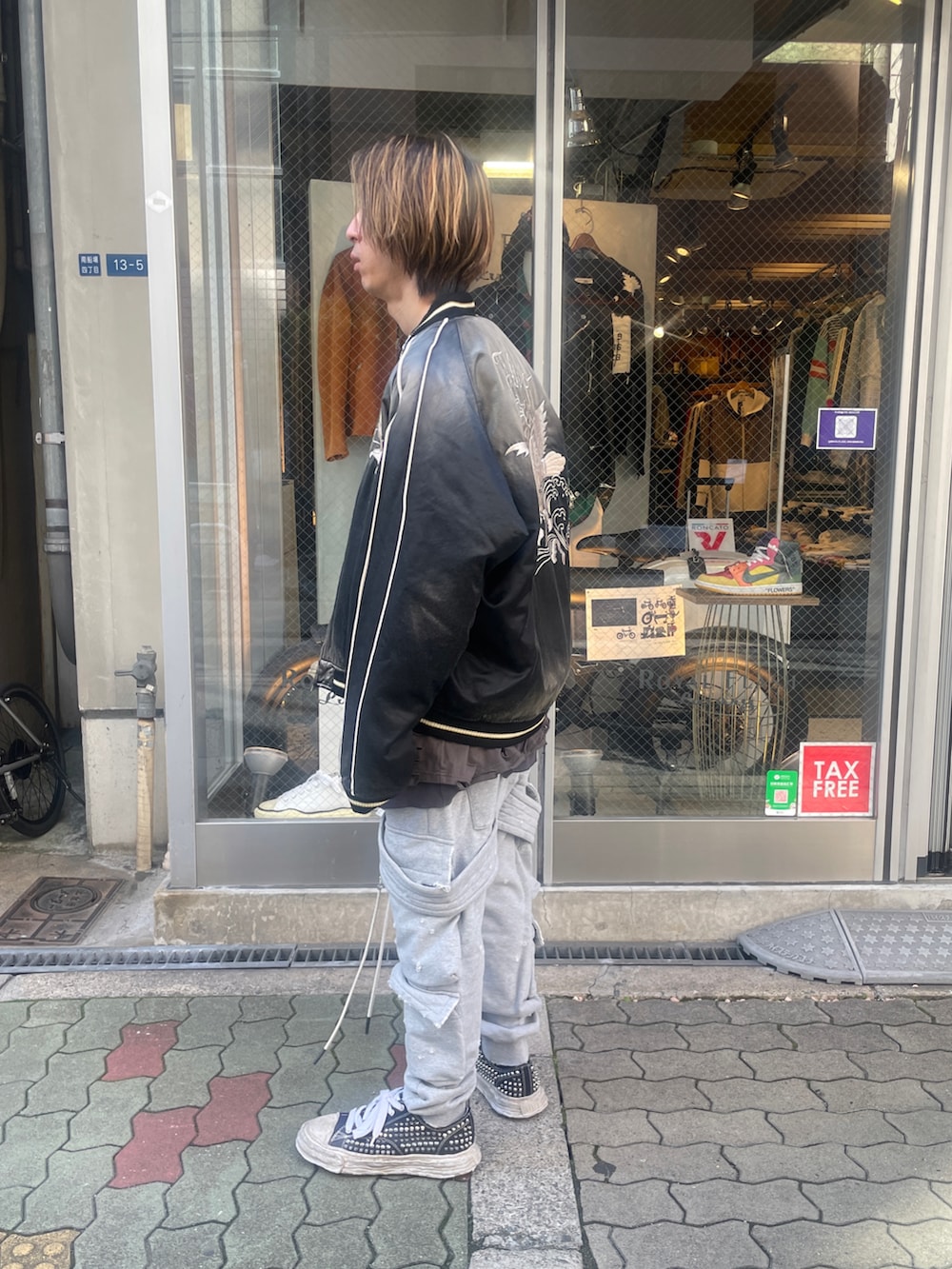 グリーン系のスカジャン、グレー系のTシャツ/カットソー、グレー系のスウェットパンツを着用したメンズの春コーディネートの2枚目の写真