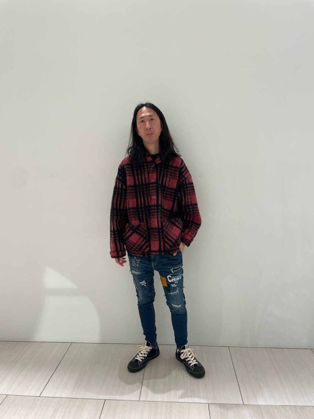 レッド系のシャツ/ブラウス、ブルー系のデニムパンツ、ブラック系のスニーカーを着用したメンズの秋コーディネートの5枚目の写真