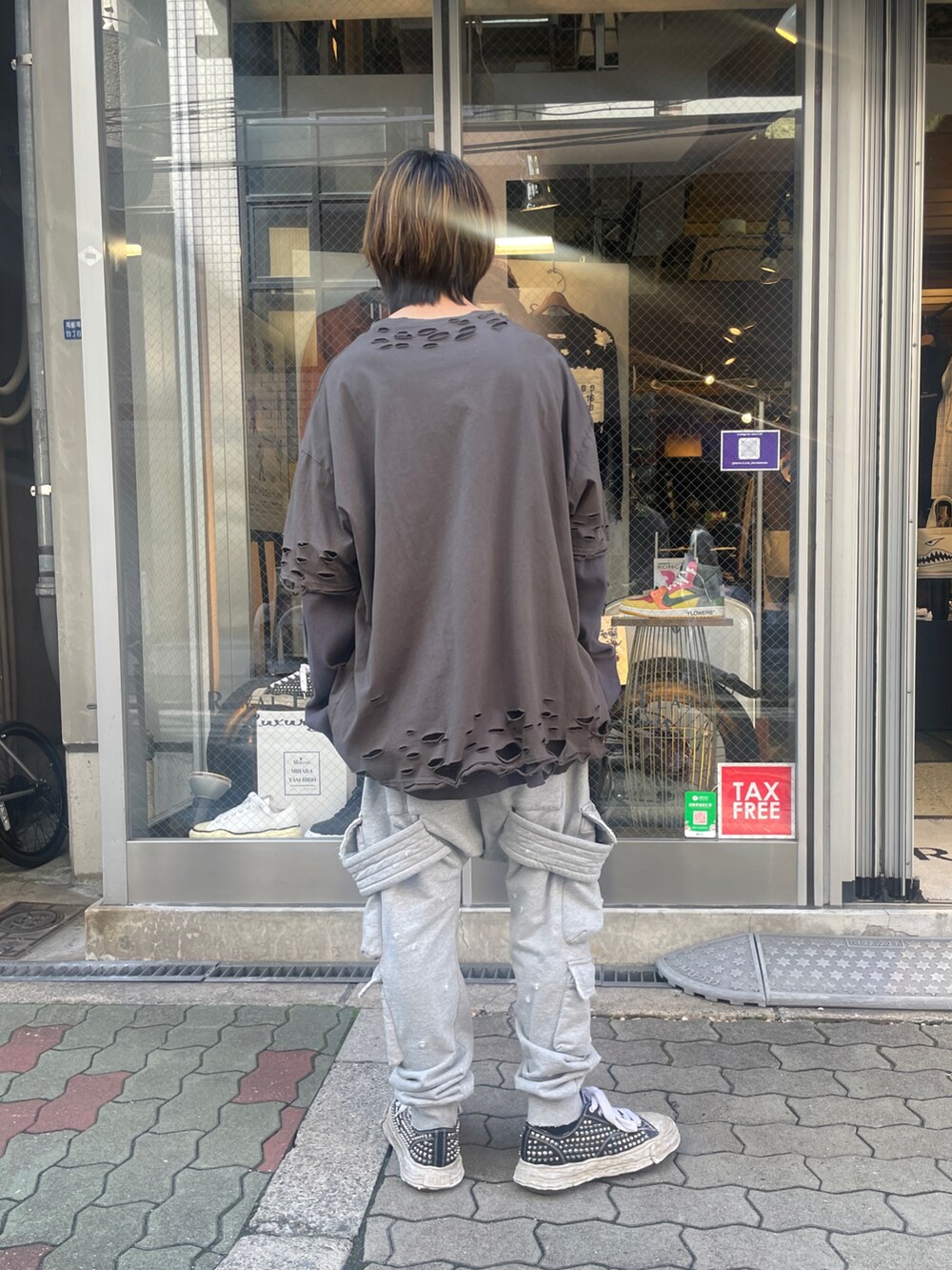 グレー系のTシャツ/カットソー、グレー系のスウェットパンツ、ブラック系のスニーカーを着用したメンズの春コーディネートの3枚目の写真