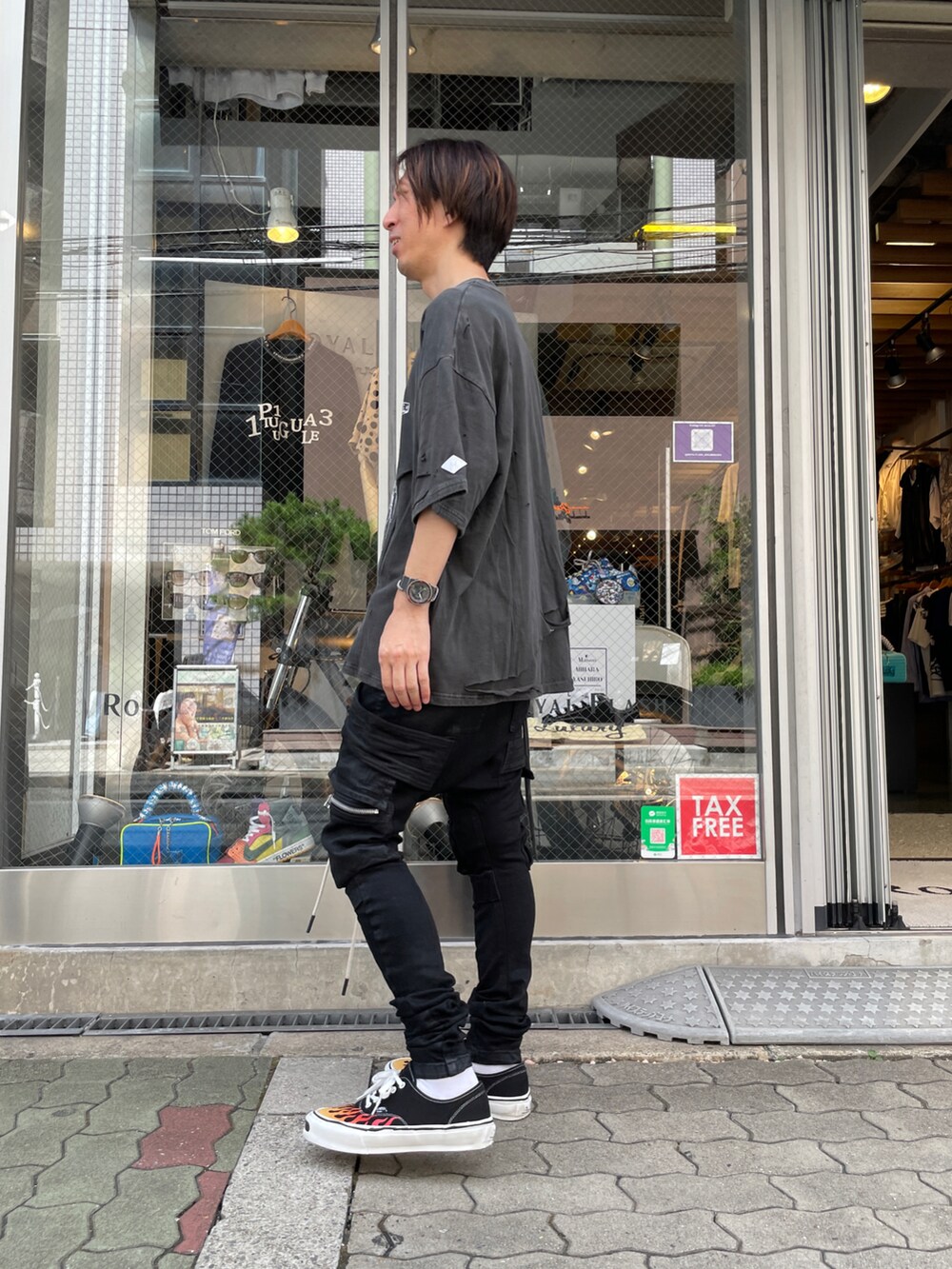 ブラック系のTシャツ/カットソー、ブラック系のカーゴパンツ、ブラック系のスニーカーを着用したメンズの夏コーディネートの2枚目の写真