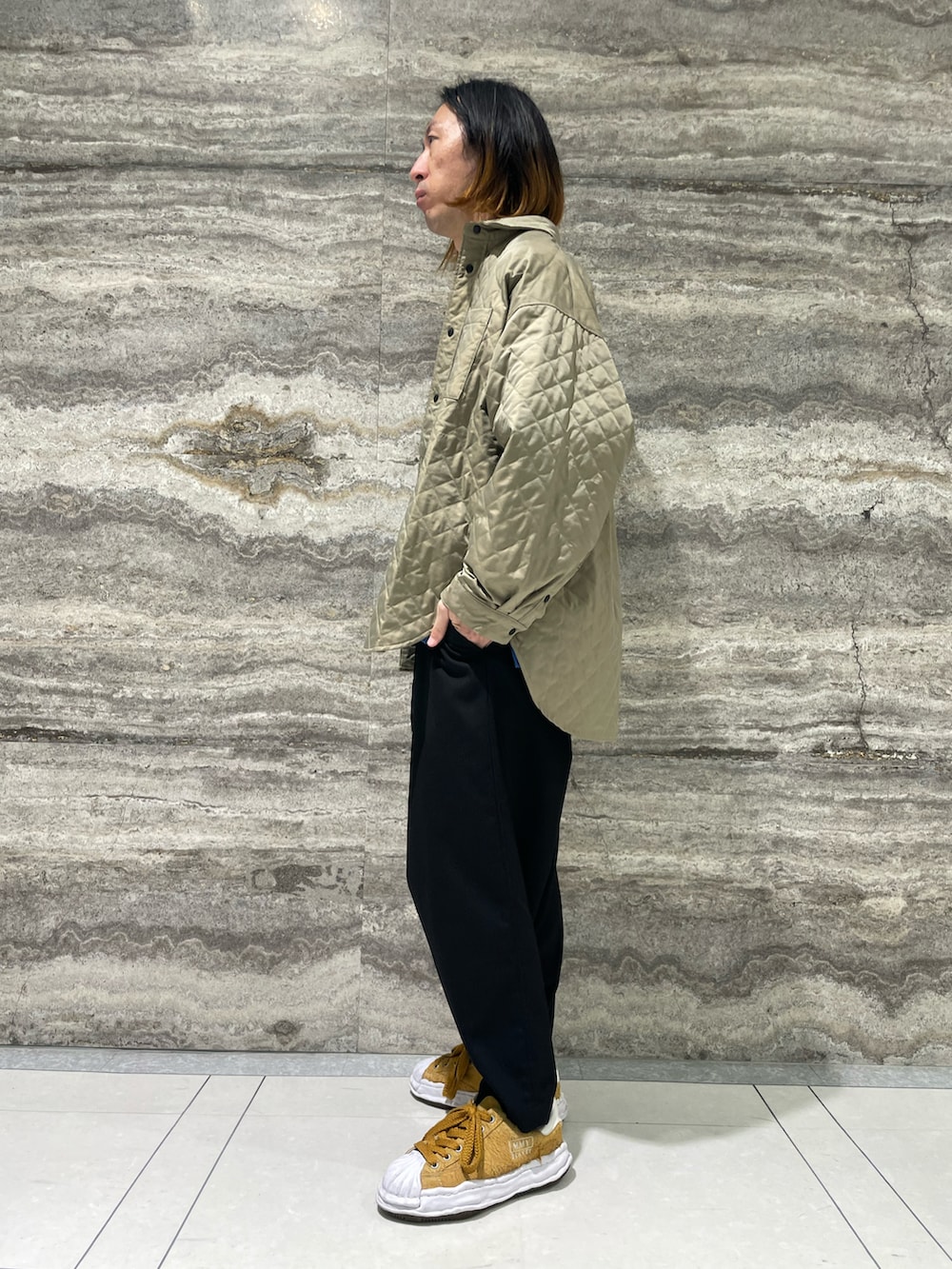 ブルー系のポロシャツ、グリーン系のシャツ/ブラウス、ブラック系のスラックスを着用したメンズの秋コーディネートの2枚目の写真