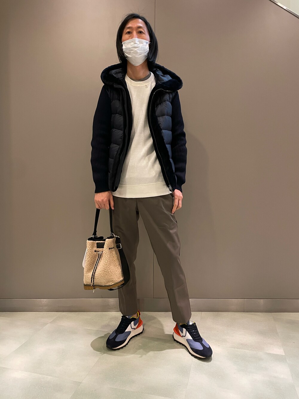 ブルー系のダウンジャケット/コート、ホワイト系のニット/セーター、ホワイト系のショルダーバッグを着用したメンズの秋コーディネートの2枚目の写真