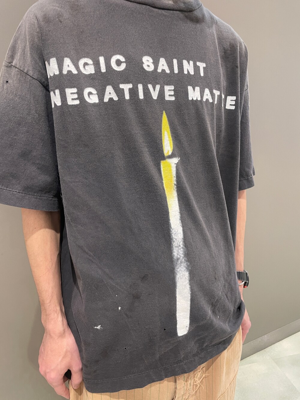 ブラック系のTシャツ/カットソー、ベージュ系のパンツ、ブラック系のスニーカーを着用したメンズの夏コーディネートの3枚目の写真