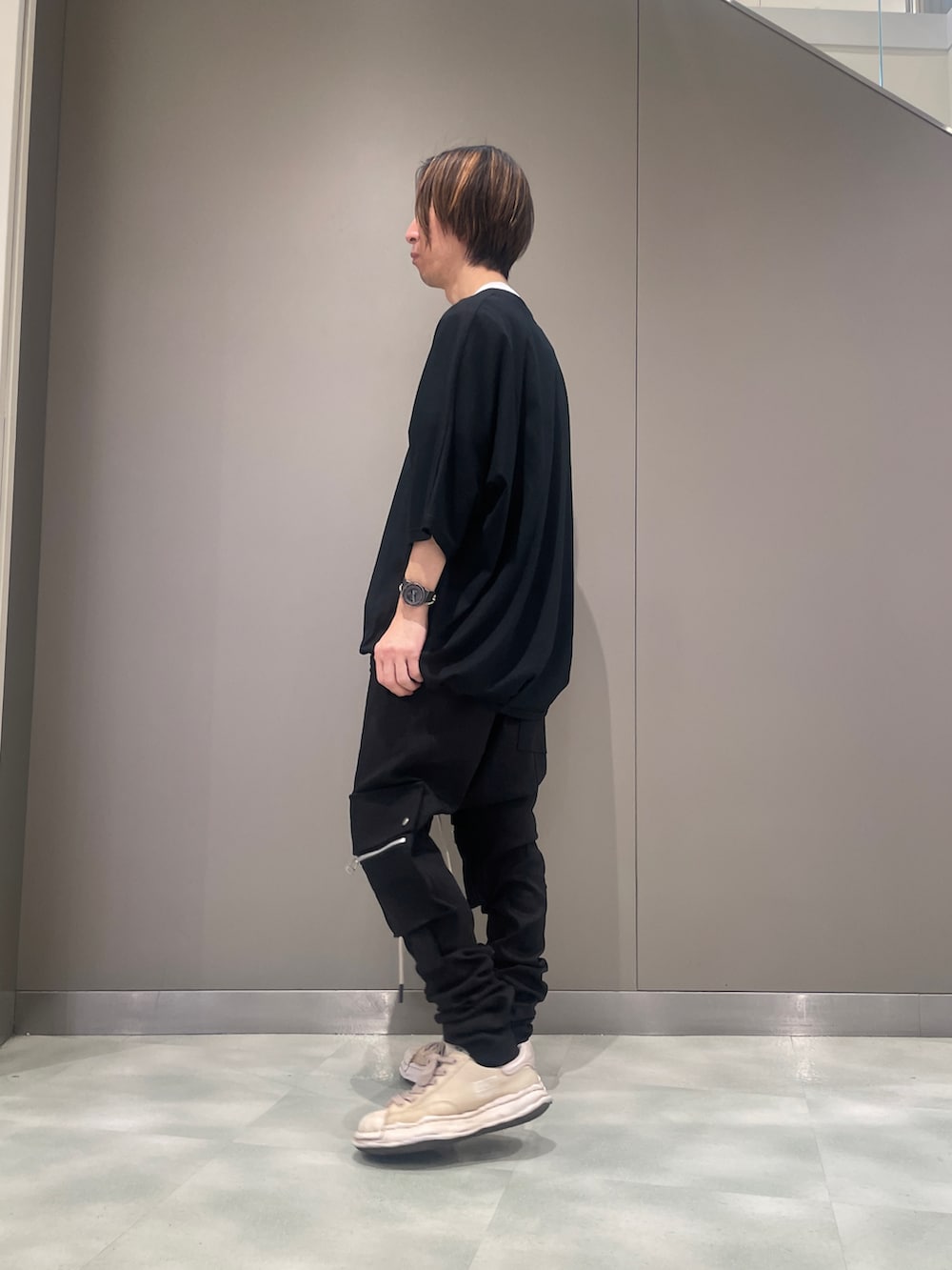 ブラック系のデニムパンツ、ブラック系のTシャツ/カットソー、ホワイト系のスニーカーを着用したメンズの春コーディネートの2枚目の写真