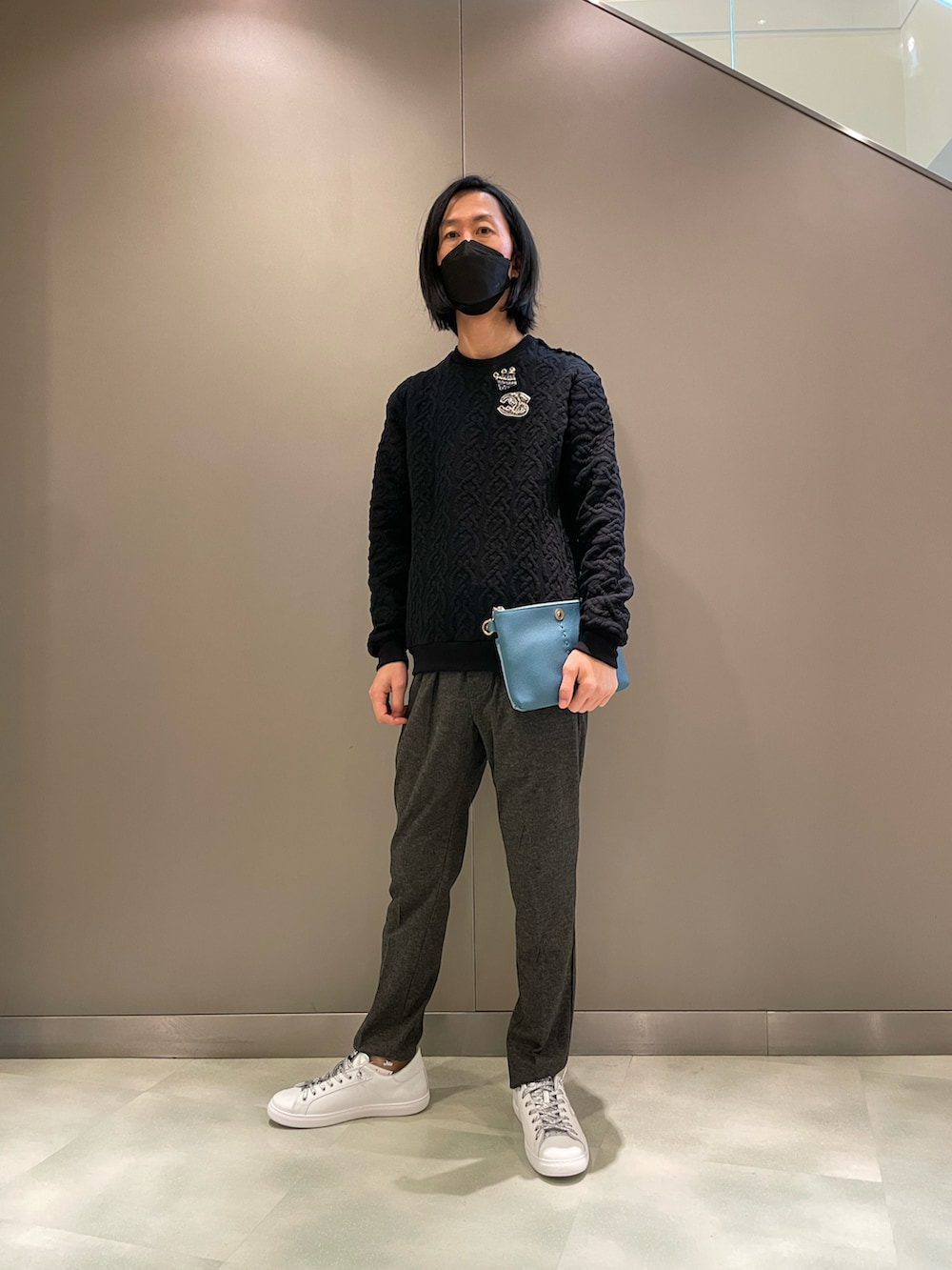 ブラック系のニット/セーター、オレンジ系のボディバッグ/ウエストポーチ、ホワイト系のスニーカーを着用したメンズの秋コーディネートの5枚目の写真