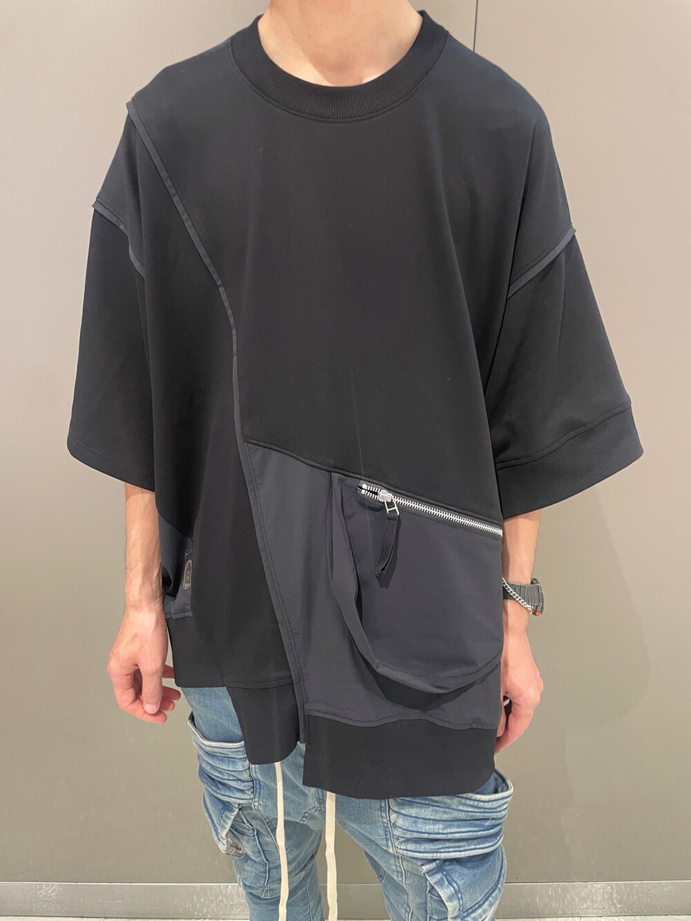 ブラック系のTシャツ/カットソー、ブルー系のデニムパンツ、ブラック系のブーツを着用したメンズの夏コーディネートの4枚目の写真