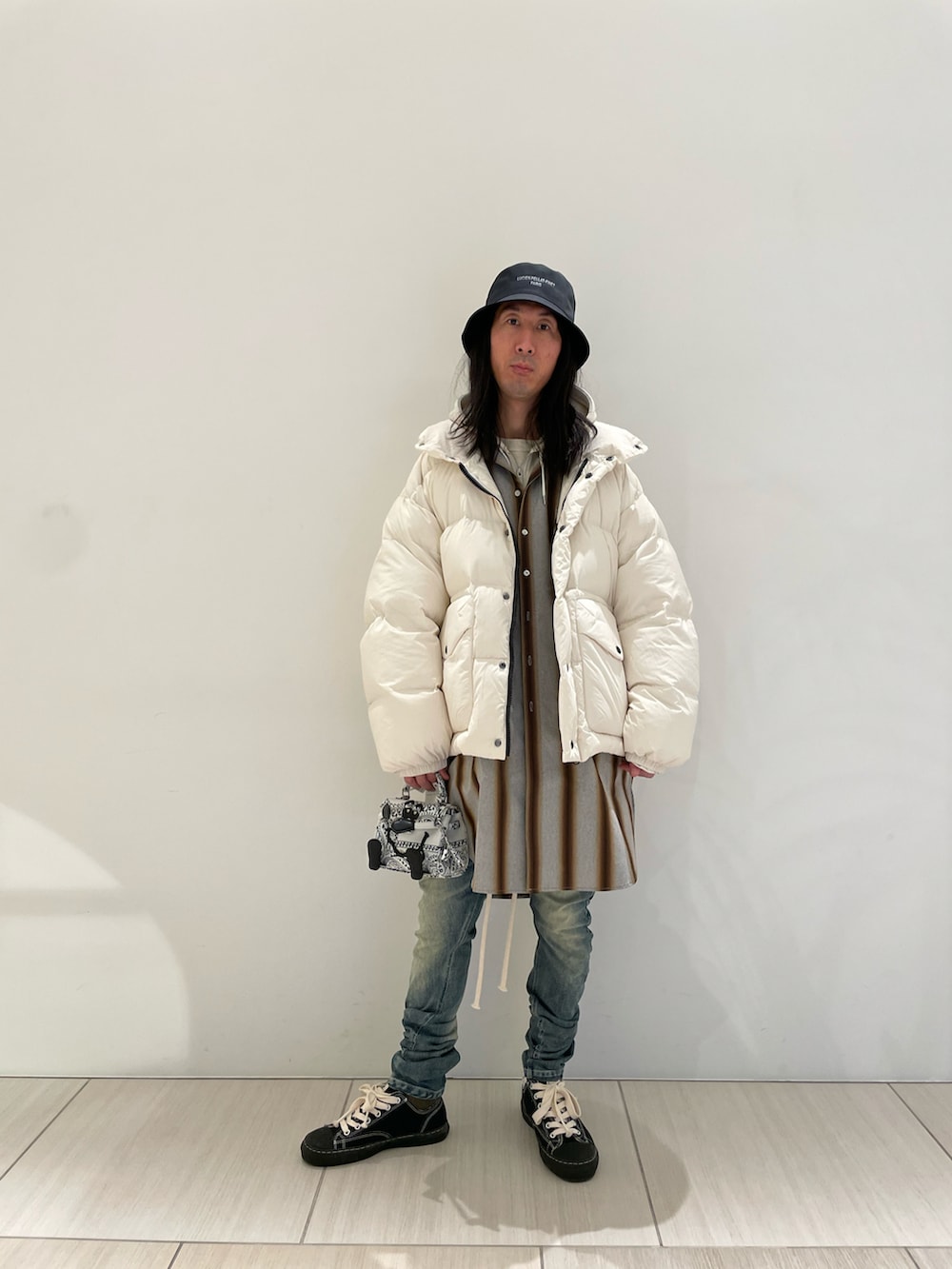 ホワイト系のダウンジャケット/コート、グレー系のトップス、ホワイト系のバッグを着用したメンズの冬コーディネートの2枚目の写真