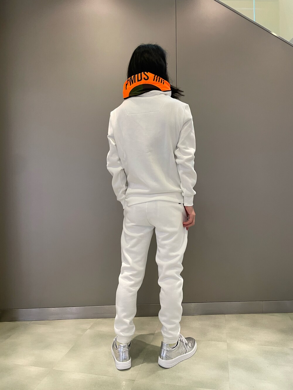 ホワイト系のパーカー、ホワイト系のパンツ、シルバー系のスニーカーを着用したメンズの秋コーディネートの2枚目の写真