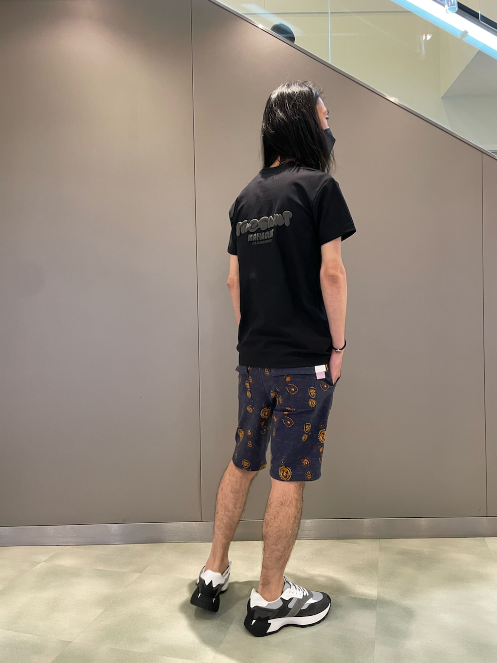 ブラック系のTシャツ/カットソー、ブルー系のパンツ、グレー系のスニーカーを着用したメンズの夏コーディネートの2枚目の写真