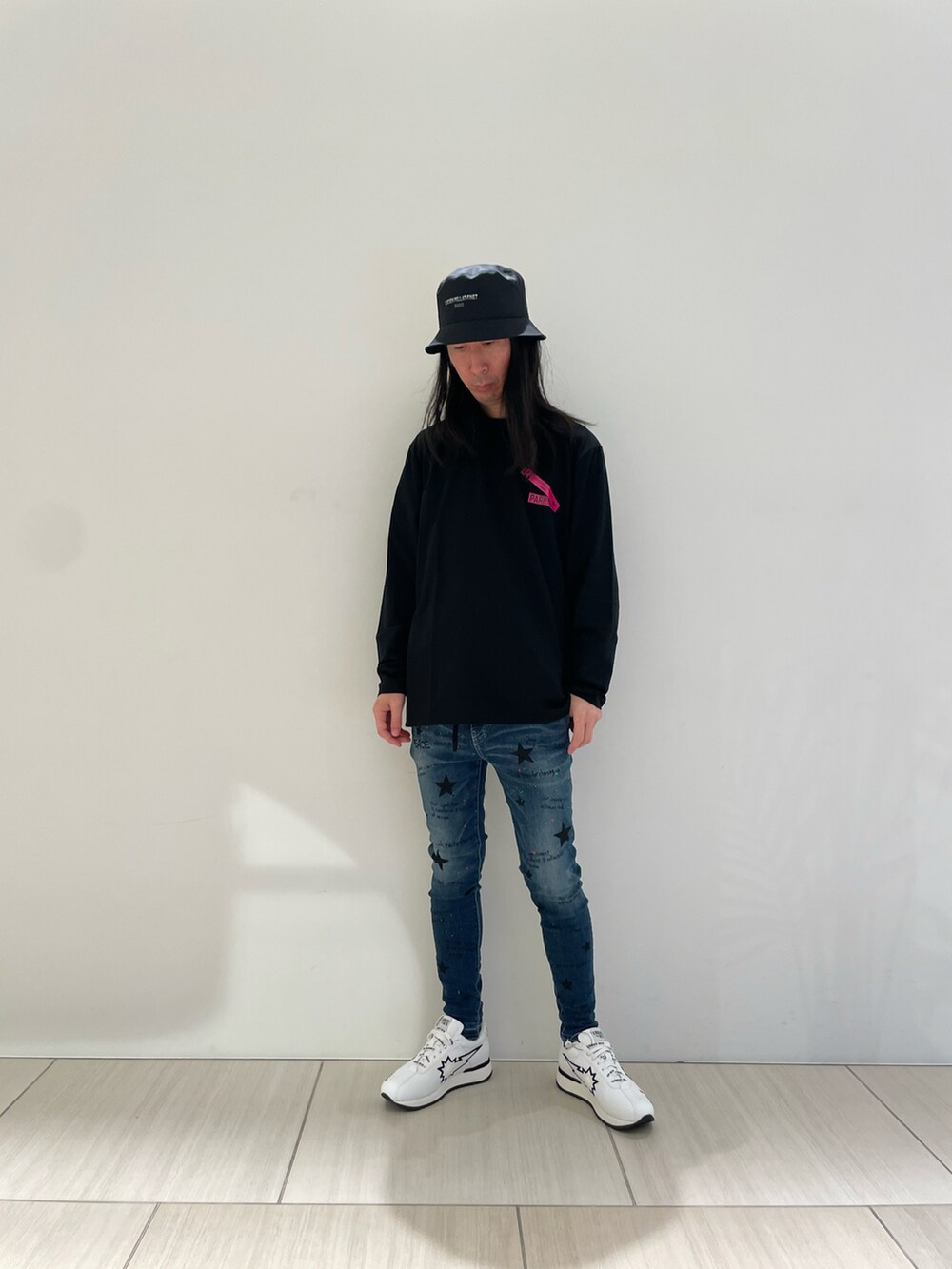 ホワイト系のTシャツ/カットソー、ブルー系のデニムパンツ、ホワイト系のスニーカーを着用したメンズの冬コーディネートの2枚目の写真