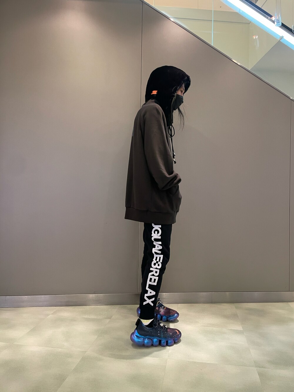 グリーン系のパーカー、ブラック系のスウェットパンツ、ブラック系のスニーカーを着用したメンズの夏コーディネートの3枚目の写真