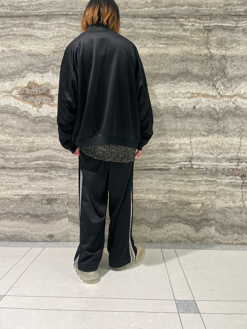 グレー系のニット/セーター、ブラック系のジャージ、ブラック系のパンツを着用したメンズの秋コーディネートの3枚目の写真