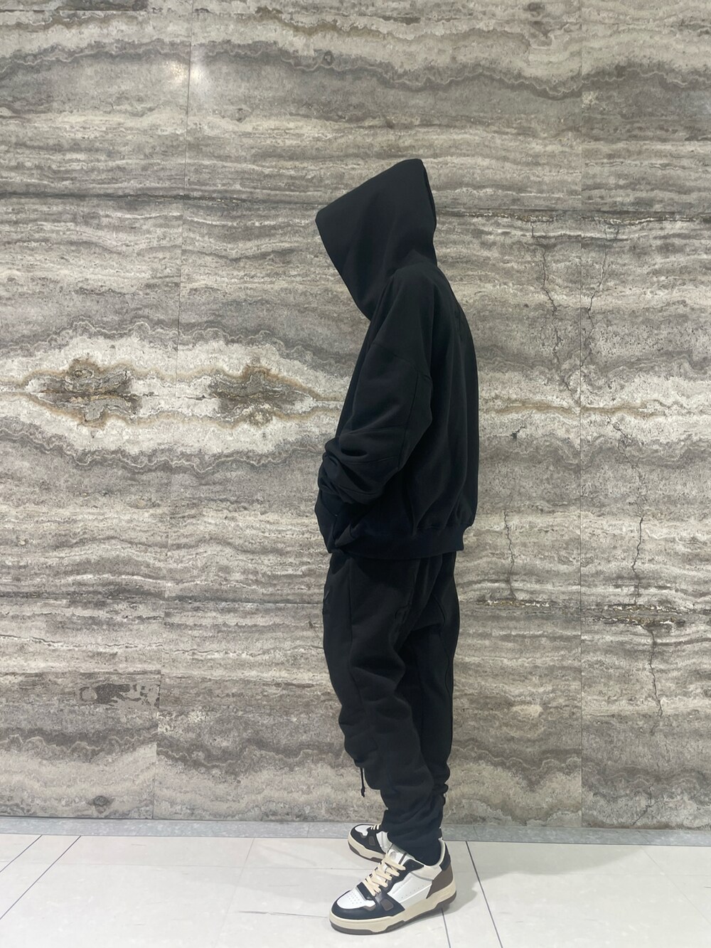 ブラック系のパーカー、ブラック系のパンツ、ベージュ系のスニーカーを着用したメンズの冬コーディネートの2枚目の写真