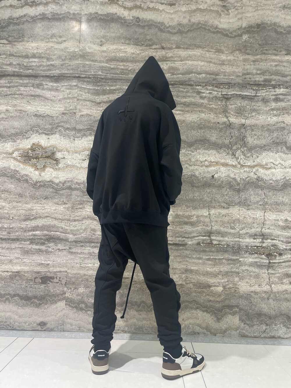 ブラック系のパーカー、ブラック系のパンツ、ベージュ系のスニーカーを着用したメンズの冬コーディネートの3枚目の写真