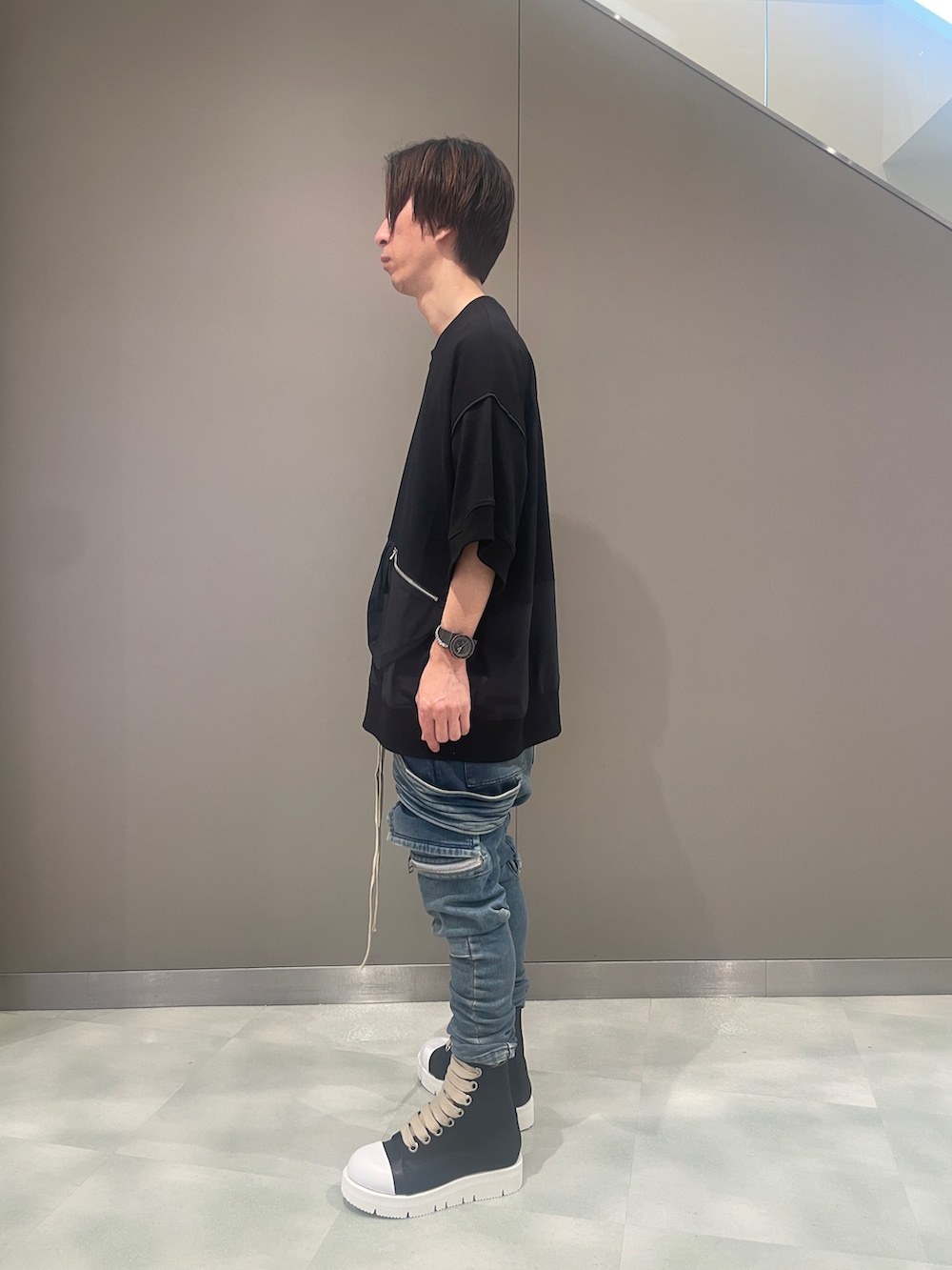 ブラック系のTシャツ/カットソー、ブルー系のデニムパンツ、ブラック系のブーツを着用したメンズの夏コーディネートの2枚目の写真