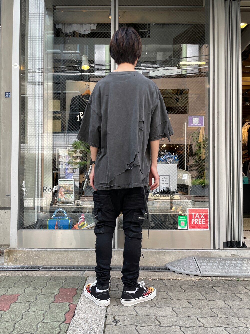 ブラック系のTシャツ/カットソー、ブラック系のカーゴパンツ、ブラック系のスニーカーを着用したメンズの夏コーディネートの3枚目の写真