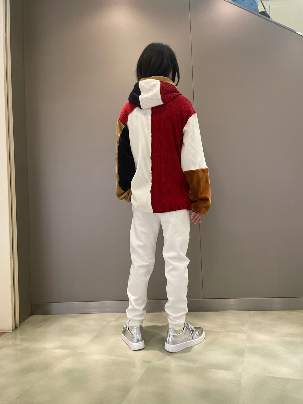 レッド系のパーカー、ホワイト系のパンツ、シルバー系のスニーカーを着用したメンズの秋コーディネートの2枚目の写真