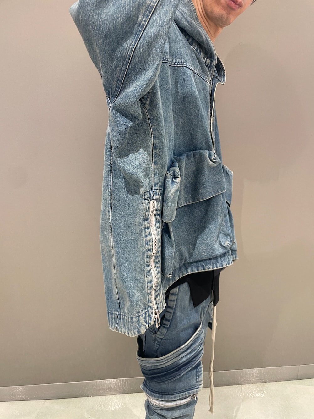 ブルー系のブルゾン、ブルー系のデニムパンツ、ブラック系のブーツを着用したメンズの夏コーディネートの5枚目の写真