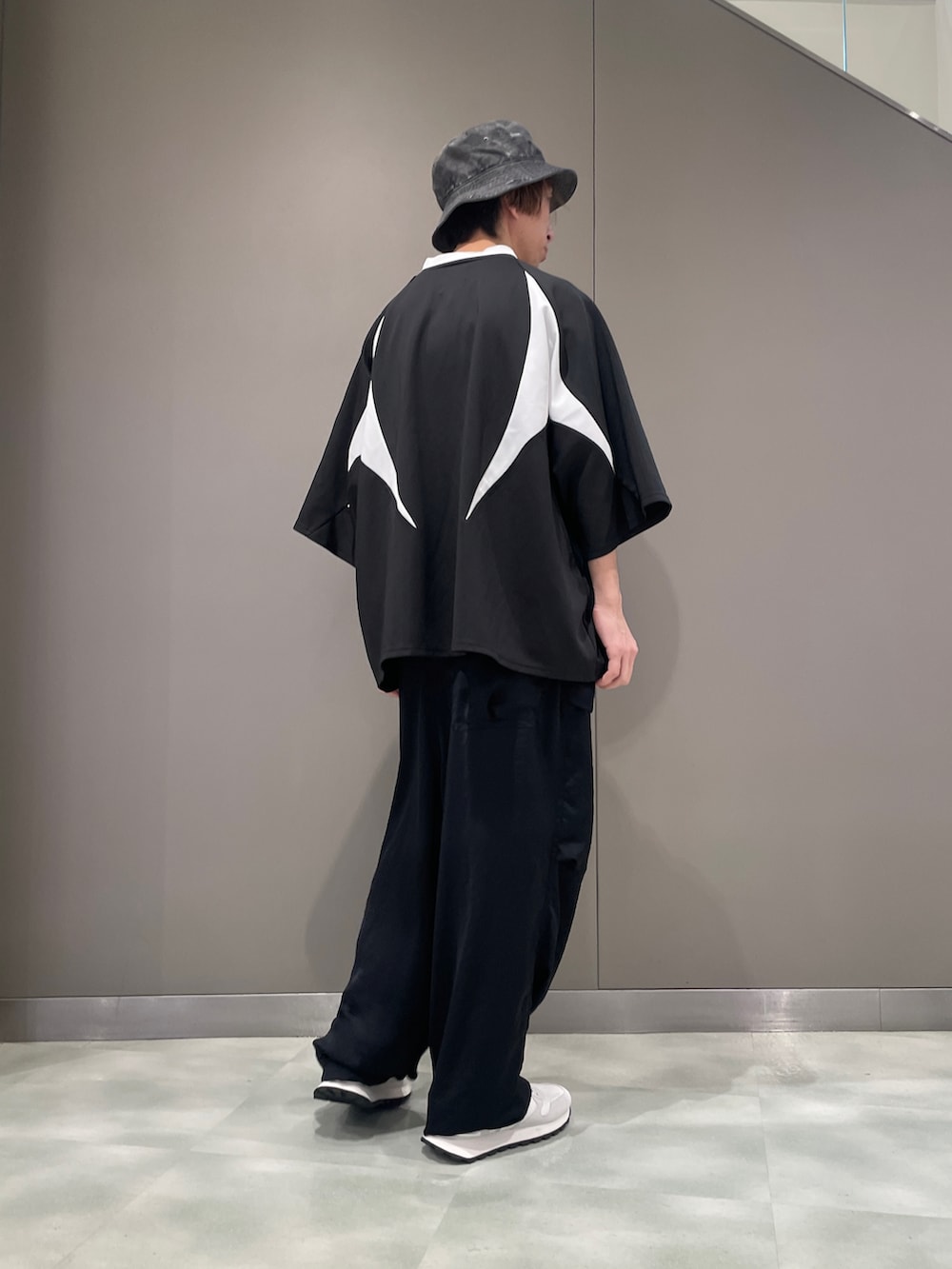 ブラック系のTシャツ/カットソー、ブラック系のパンツ、ホワイト系のスニーカーを着用したメンズの春コーディネートの2枚目の写真